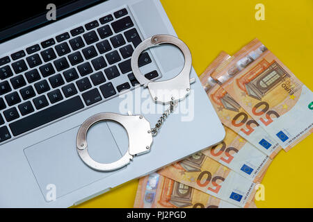 Handcuffs on keyboard, symbolizing cyber crime Stock Photo