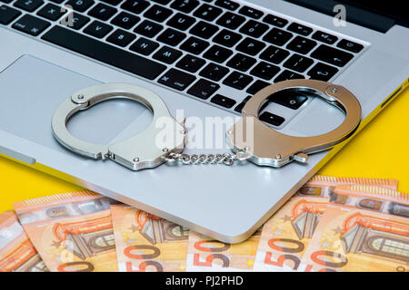 Handcuffs on keyboard, symbolizing cyber crime Stock Photo