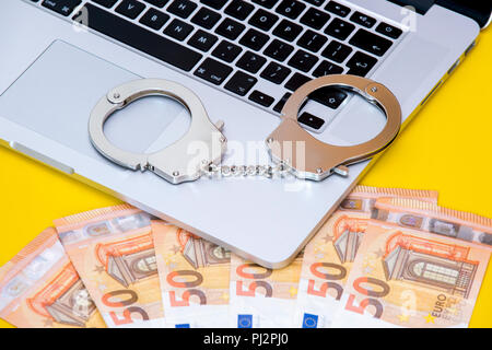 Handcuffs on keyboard, symbolizing cyber crime Stock Photo