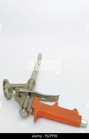 used mounting foam gun with orange plastic handle Stock Photo