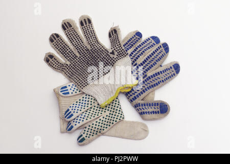 cotton gloves for gardening, with yellow hem and black rubber anti slip dots, lies on top sides, in small stack Stock Photo