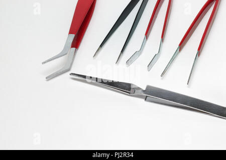 steel tweezers for precision electronics repairing. Different types of tools: pointed tip, curved forceps and clamp on foreground Stock Photo