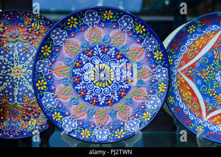 Beautiful blue plate with traditional Turkish flower pattern, colorful painting on the dishes. Souvenir shop. Stock Photo