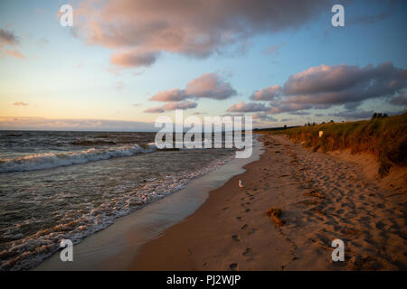 Oval Beach at Sunset with light waves and clouds in a blue sky - Saugatuck, MI Stock Photo
