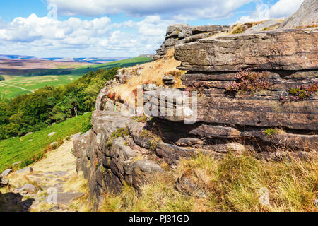 Peak District National Park, Derbyshire, England. Stacked rocks in Stanage edge, with the fields and pastures on the background, selective focus Stock Photo