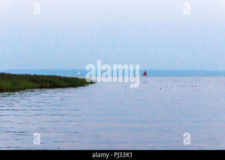 Vistula Bay is a hot summer day. Sailing yachts on the horizon. Site about travel, fishing, nature, sea, yachts, ships. Stock Photo