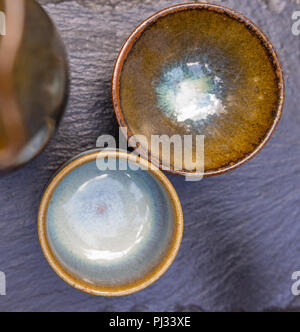 Close-up of two Japanese shells for sake on a slate plate. Stock Photo