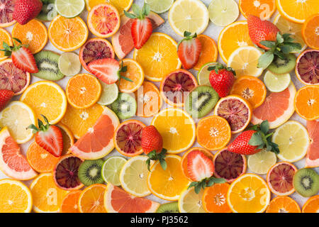 Colourful fruit pattern, oranges, clementines, blood oranges, kiwis, strawberries and grapefruits on white table background, top view, selective focus Stock Photo