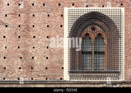 detail of a renaissance window with a pointed arch, in Sforza castle of Milan, with the wall made of adobe bricks Stock Photo