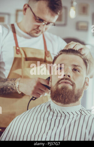 Man during trimming hair in a barbershop Stock Photo