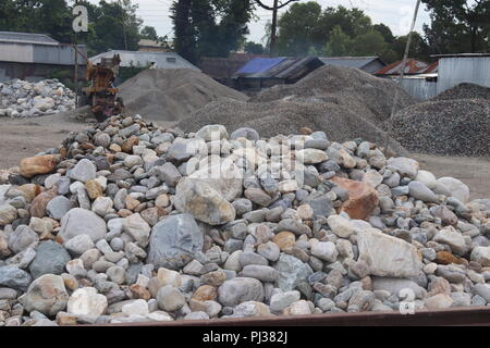 big granite stones boulders of various forms and sizes set.white stone floor in the garden.white stone wall background. Stock Photo