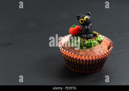 Halloween Holiday food colorful fancy brownies cupcake with black cat and pumpkin fondant decorate Stock Photo