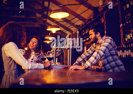 Young women interacting with each other at counter Stock Photo