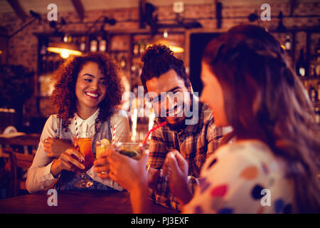 Young friends interacting with each other having drinks Stock Photo