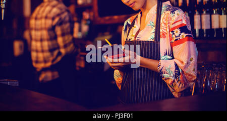 Waitress taking an order on notepad at counter Stock Photo