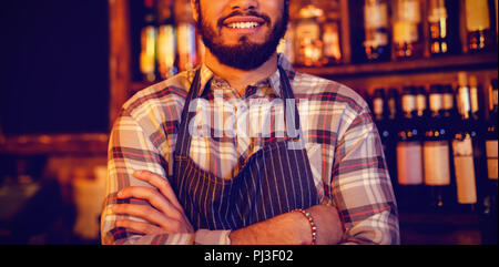 Portrait of smiling waiter standing with arms crossed Stock Photo
