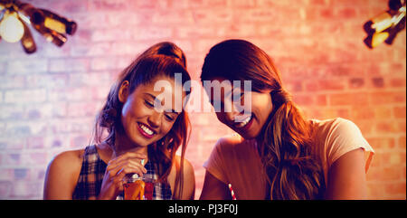 Two young women using mobile phone Stock Photo