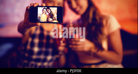 Young women taking a selfie while having cocktail drinks Stock Photo
