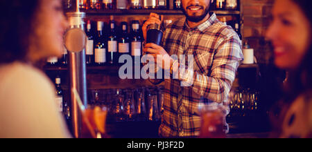 Bartender mixing a cocktail drink in cocktail shaker Stock Photo