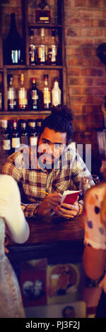 Bartender taking an order on notepad at counter Stock Photo