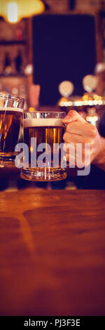 Two young men toasting their beer mugs Stock Photo