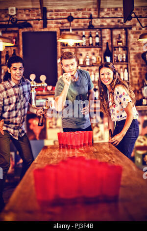 Group of happy friends playing beer pong game Stock Photo