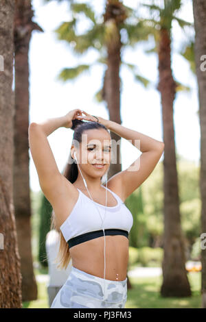 sexy woman in sport bra and panties touching hair and looking away isolated  on grey Stock Photo by LightFieldStudios