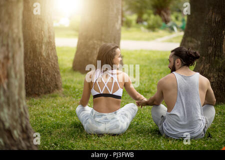 Young couple doing yoga outdoors Stock Photo