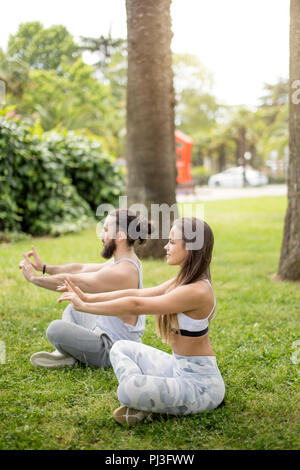Young couple doing yoga outdoors Stock Photo