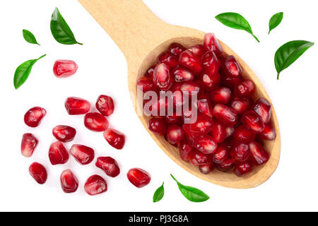 pomegranate seeds in wooden spoon decorated with green leaves isolated on white background. Top view. Flat lay pattern Stock Photo