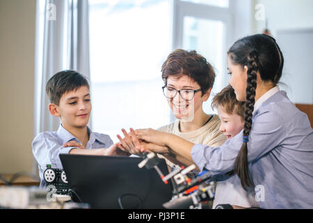 Happy children learn programming using laptops on extracurricular classes Stock Photo