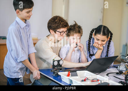 Happy children learn programming using laptops on extracurricular classes Stock Photo