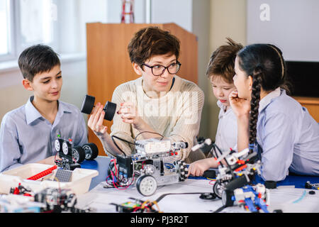 Happy children learn programming using laptops on extracurricular classes Stock Photo