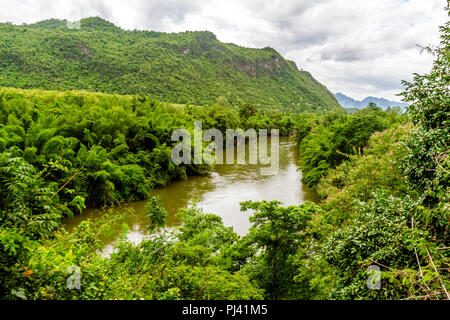 The train runs past the Kwai River and remote jungle areas on the way to Hell Fire Pass. Stock Photo