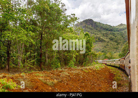 Thailand train on the way to Hell Fire Pass from River Kwai Bridge. The train is running through jungle and river area. Stock Photo