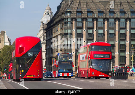 A pair of New Routemaster red double decker London buses passing each other on Westminster Bridge. Stock Photo