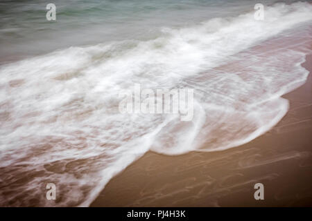 artistic moving blurred background of the foam of the waves that wash up on the beach Stock Photo