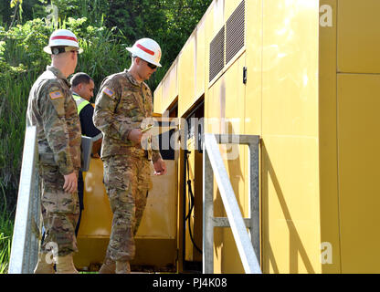 249th Engineer Battalion (Prime Power) is a U.S. Army unit specializing in power generation and electrical infrastructure support. The archival photographic record documents personnel inspecting a back-up generator at La Plata Lake Dam, Toa Alta, Puerto Rico, in August 2018 during post-Hurricane Maria recovery operations. The historical photographic print captures field engineering assessment procedures and equipment deployment. Stock Photo