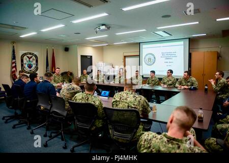 SASEBO, Japan (Aug. 29, 2018) Rear Adm. Dave Welch, commander, Naval Surface and Mine Warfighting Development Center (SMWDC), far left, speaks to junior officers assigned to Commander Task Force 76 onboard Commander, Fleet Activities Sasebo. SMWDC is one of the Navy's five Warfighting Development Centers and its mission is to increase the lethality and tactical proficiency of the Surface Force across all domains. (U.S. Navy photo by Mass Communication Specialist 3rd Class Geoffrey P. Barham) Stock Photo