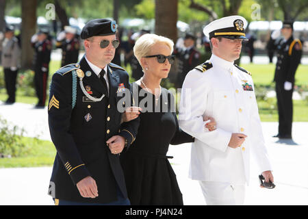 Cindy McCain, wife of Sen. John McCain, is escorted by her sons, Navy Lt. Jimmy McCain (left) and Arizona Army National Guard Sgt. Jack McCain (right) to a memorial service for her husband Aug. 29, 2018, at the Arizona State Capitol Building. McCain, a Republican Senator from Arizona, lost his battle with brain cancer earlier this week. (Arizona Army National Guard photo by Staff Sgt. Brian A. Barbour) Stock Photo