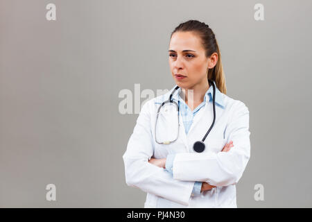 Angry female doctor looking away and thinking about something. Stock Photo