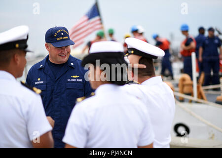 Cmdr. Michael Sarnowski, Commanding officer of the Coast Guard Cutter Tahoma, smiles as he greets Columbian naval officials in Cartagena, Colombia for the annual UNITAS exercise Aug. 30, 2018. UNITAS is a combined Latin American and U.S. exercise that promotes cooperation, understanding and partnership among the participating navies in order to respond as a unified force to a wide variety of maritime missions. Stock Photo