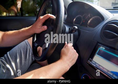 The man using the key starts the car engine. Stock Photo
