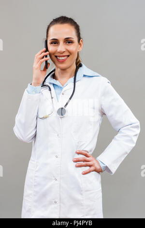 Beautiful female doctor using mobile phone. Stock Photo