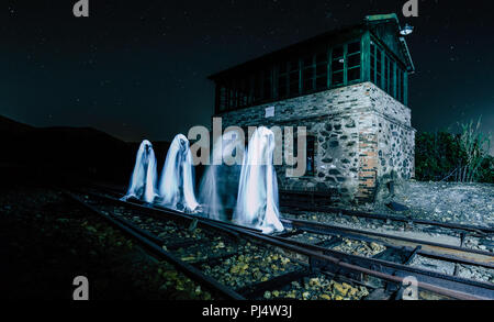 Four ghosts walking on the train track in front of the house Stock Photo