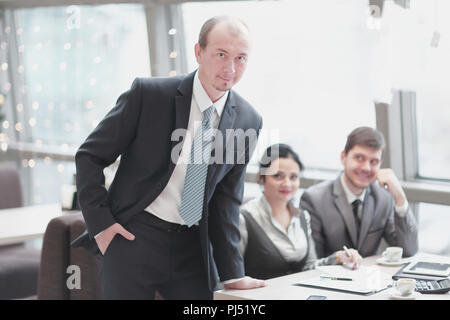 close up.confident businessman standing near desktop Stock Photo