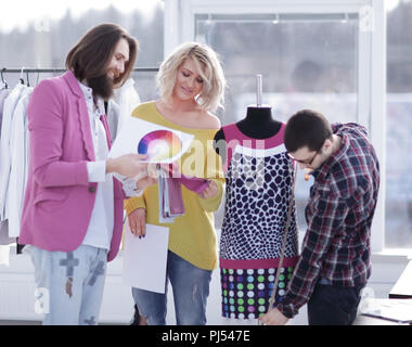 tailor and designers discussing new fabric patterns in creative workshop Stock Photo