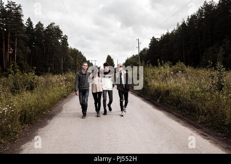 Young friends walking on countryside road Stock Photo