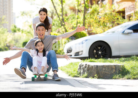 Happy young family playing with skateboard Stock Photo