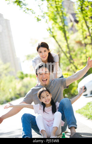 Happy young family playing with skateboard Stock Photo